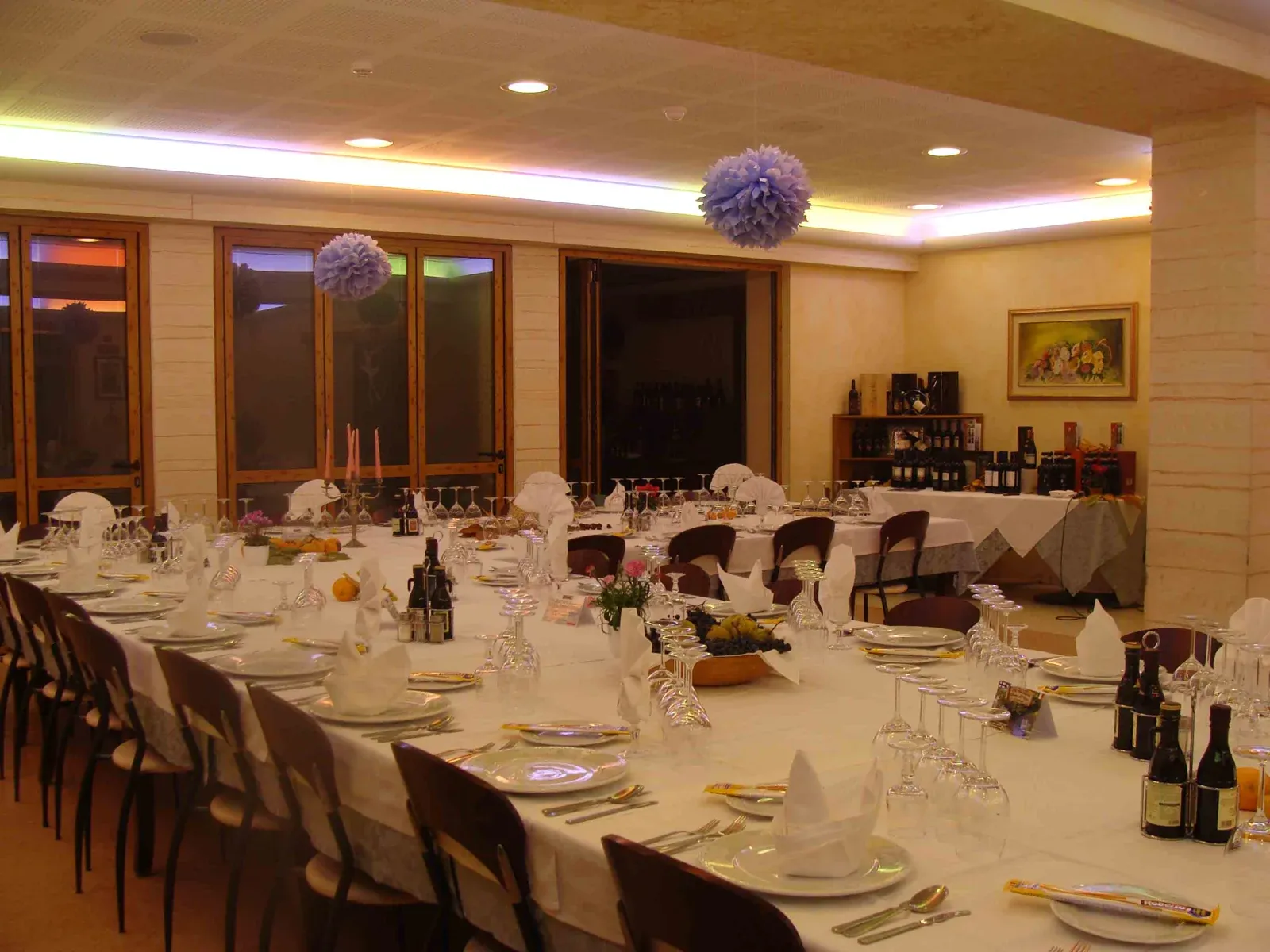 La sala grande della trattoria con le colonne e le vetrate sul bosco