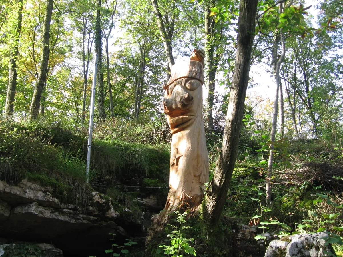 A wooden sculpture along the trail in the woods