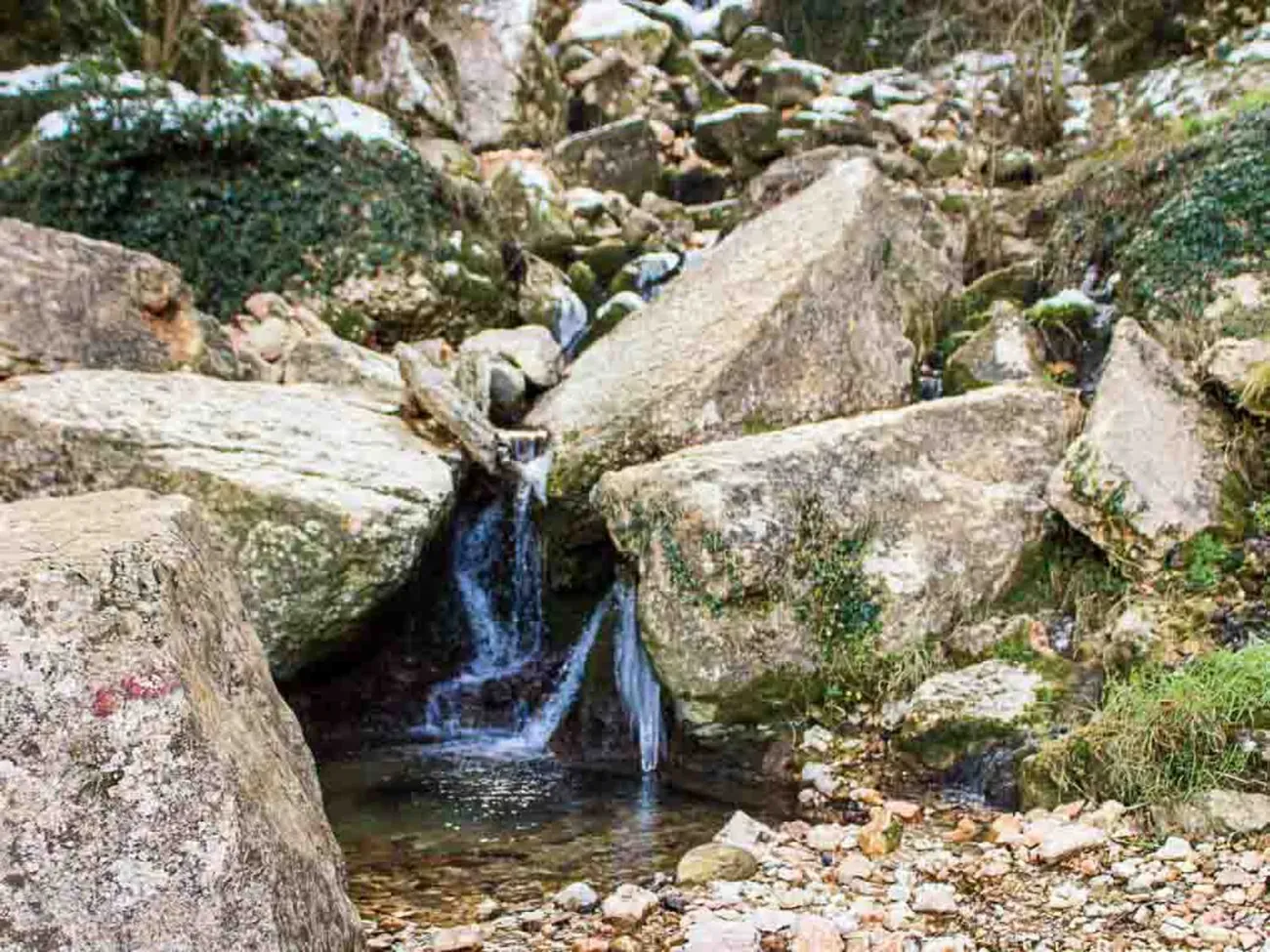 A clear stream of water along the path beneath the Ponte di Veja