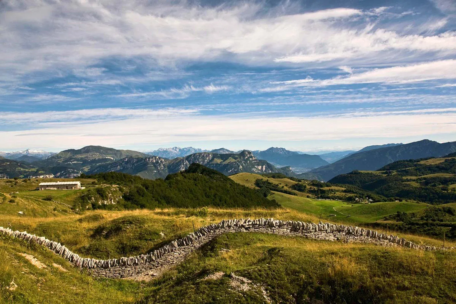 The pastures and dry-stone walls of the Lessinia, with the mountains in the background